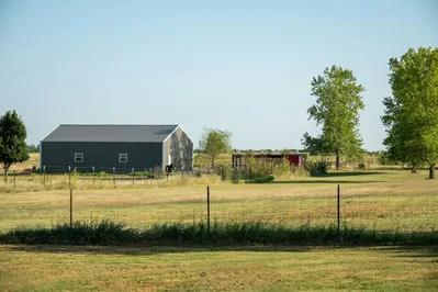 Peaceful farm scene with barn, trees, and open land in Oklahoma.