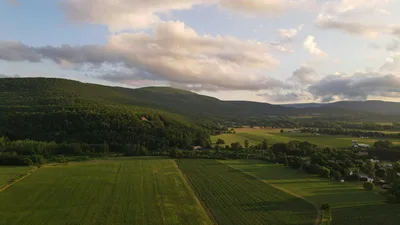 Aerial view of rolling green hills and farmland in the Hudson Valley at sunset.
