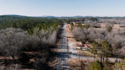 Aerial view of a rural Alabama road cutting through forests and agricultural fields