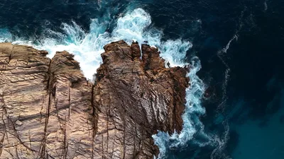 Drone shot of waves crashing on rugged cliffs near Perth, WA, Australia.