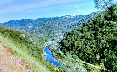Aerial view of the North Fork American River Canyon in Auburn, California, showing the rugged forested hills and the river below.