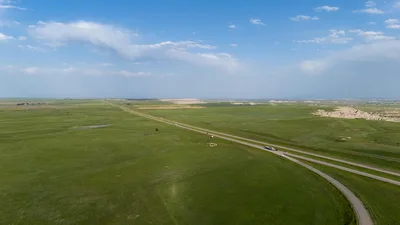 Breathtaking aerial view of vast grasslands under a clear blue sky, representative of the North Dakota prairie around Bismarck.