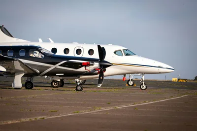 Private aircraft parked on a sunny airport tarmac under a clear blue sky