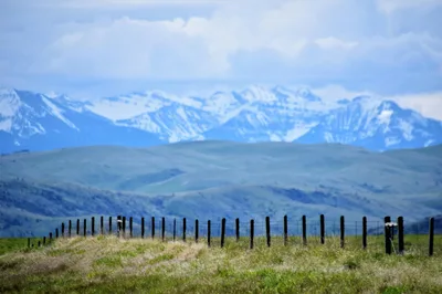 Aerial-style view of snow-capped Montana mountains and wide open valley fields