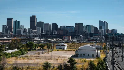 View of Denver's skyline against clear blue skies with an industrial foreground.