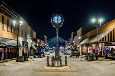 Illuminated street scene featuring a classic clock tower at night in downtown Cape Girardeau, MO.