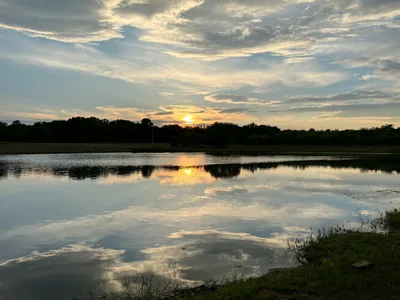 Tranquil sunset over a reflective lake in Texas, capturing the serene beauty of the region.
