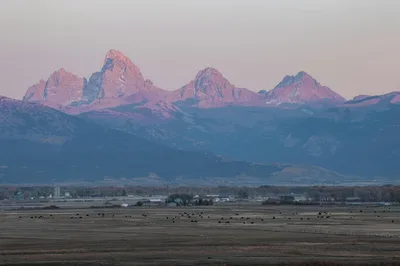 Wide sunset view of the Teton mountains and the lush Teton Valley, where Driggs/Reed Memorial Airport is located.
