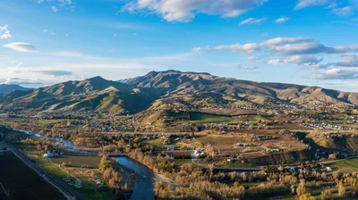 Aerial view of the Sunnyslope landscape near Wenatchee, Washington, showing lush agricultural fields and the rugged Cascade foothills.