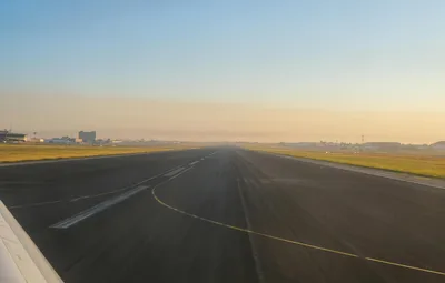 Empty airport runway at sunrise with a glowing horizon