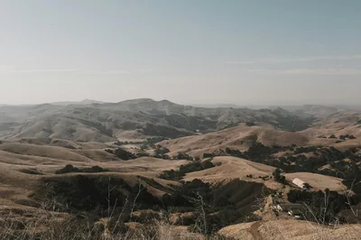Expansive view of California's rolling hills and open sky, captured at dusk, showcasing natural beauty.