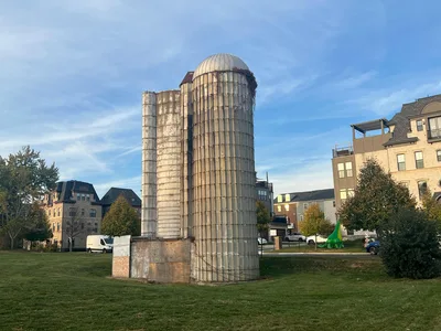 A vintage silo stands amid modern buildings and greenery in Gaithersburg, MD.