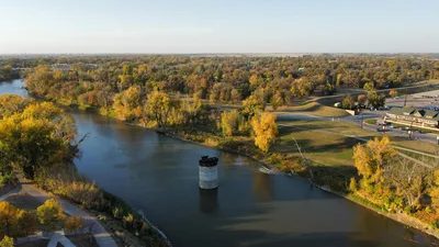 A scenic aerial view of a river surrounded by fall foliage in Grand Forks, North Dakota.