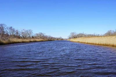 Serene wide-angle view of the North River in Marshfield, Massachusetts, under a clear blue sky.