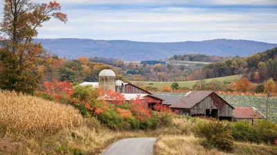 Autumn view of a scenic farm with red barns, fields, and colorful foliage in Williamsport, PA.