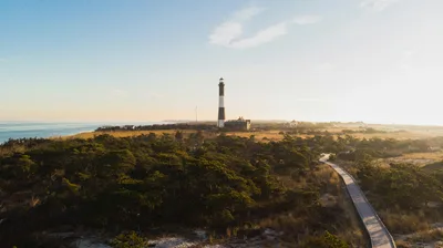 Aerial view of Fire Island Lighthouse at sunset, a major landmark for pilots flying into KISP