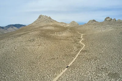 Aerial drone view of a winding dirt road in the arid high desert of Inyokern, California.