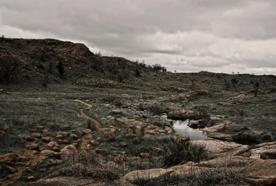 Moody view of the Wichita Mountains near Lawton, Oklahoma, with rocky terrain and dramatic clouds.