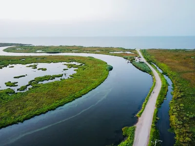 Aerial view of Louisiana wetlands and bayou under a soft sunrise, representative of the approach to Lafayette Regional Airport
