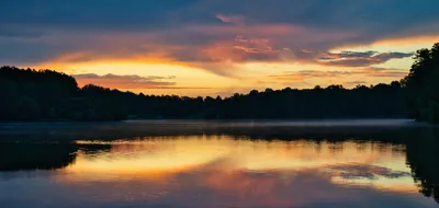 Vibrant sunset reflecting on a tranquil lake in Lawrenceville, GA, capturing the scenic approach to Gwinnett County.