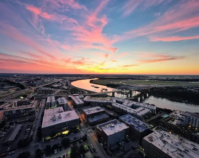 Aerial view of Kansas City at sunset with the Missouri River and the city skyline in the distance.