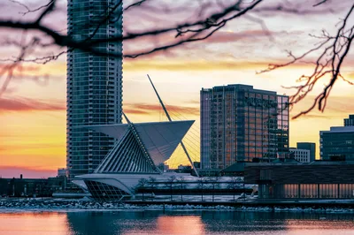 Beautiful sunset view of Milwaukee skyline featuring the iconic Art Museum architecture along the Lake Michigan shoreline.