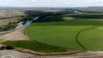 Aerial view of expansive circle irrigation fields alongside a winding river in the Columbia Basin, typical of the approach to Pasco, WA.