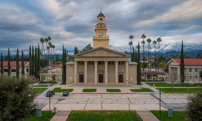 Aerial view of the University of Redlands clock tower with the snow-capped San Bernardino mountains in the background