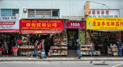 Street view of an Asian market with shops and pedestrians in an urban setting with vibrant colors.