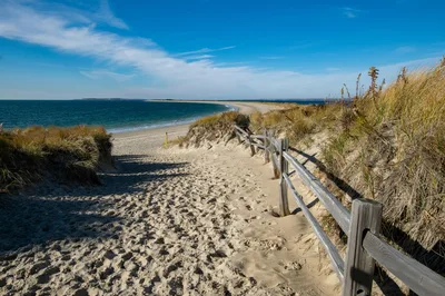 Discover a serene sandy path leading to the ocean in Westerly, Rhode Island.