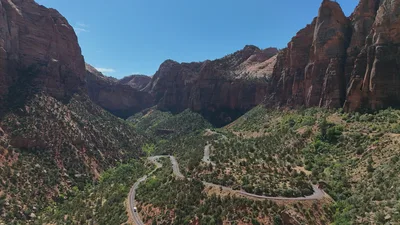 Aerial view of the winding Zion-Mount Carmel Highway through red rock canyons in Utah.