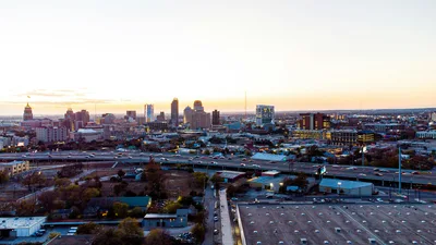 Aerial sunset view of the San Antonio skyline featuring the Tower of the Americas.