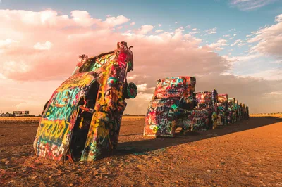 Colorful graffiti on cars at Cadillac Ranch in Amarillo, Texas at sunset.