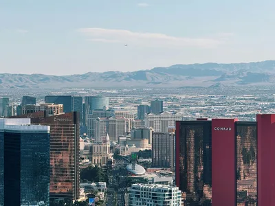 Aerial view of the Las Vegas Strip and distant mountains under a clear blue sky