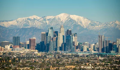 Aerial view of downtown Los Angeles skyline with the snow-capped San Gabriel Mountains in the background