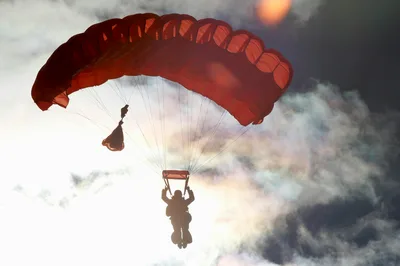 Silhouette of a skydiver under canopy at sunset, capturing the aviation spirit of Zephyrhills