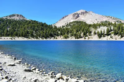 Crystal clear Lake Helen with snow-capped Lassen Peak in Lassen Volcanic National Park