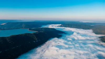 Stunning aerial view of a mountain landscape shrouded in morning clouds and vibrant scenery.